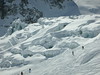Vallée Blanche April 2006 : On 8 April 2006, Paula and I plucked up the courage to ski the Vallée Blanche and we didn't regret it. The Vallée Blanche is described as the most famous lift-accessed ski descent in the world. The 20km high-mountain itinerary, off-piste, "ski run" from the 3,800m (12,500 ft) Aiguille du Midi, was nothing short of breathtaking. Skiing on glaciers amongst 3,000m+ granite peaks, crevasses and seracs was absolutely awesome. We were truly *in* the mountains rather than *on* the mountain. 

We set off at around 8.00 am with a ride up on the Aiguille du Midi cable car, the second part of which is the longest single span cable car ride in the world, with a maximum declivity of 100%! If we hadn't have been so apprehensive about the impending walk down the ridge, we might have taken more notice of the amazing views on the way up. At the top, in the ice tunnel, we put on our harnesses and avalanche transceivers and, to our relief, our guide bound our skies and poles together so that he could carry them all. 

Roped together we began the walk down the ridge. This was the part that we had dreaded. We grabbed on to the fixed ropes and side stepped down the make shift "steps" that had been cut into the ridge. It wasn't quite as bad as we had expected; we were in quite a ditch, and, despite the almost vertical drop on either side, we never really felt in any danger, although at times it was pretty slippy underfoot! I think we might have felt differently, if we had had to carry our own skis! I guess it took around 20-30 mins to reach the bottom and though it was tiring in the thin air, we made it without any problem. After that it was a matter of clipping into our skis and getting going. 

There had been quite a wind blowing on the ridge, but once we skied down a bit, the weather was perfect; not a cloud in the deep blue sky. Our initial route took us in the direction of the Mont Blanc Panoramic cable car, which, in the summer only, takes people an on amazing journey from the Aiguille du Midi to Helbronner Point in Italy over the Glacier du Geant. I remembered thinking in the past how fabulous it would be to go on that cable car and look down on the glacier - this was way better though - we were actually *on* the glacier.

On the tracked snow, the skiing was relatively easy. On a couple of occasions our guide took us off the tracked route onto the "fresh" stuff; whilst it looked like powder, the top surface had been baked into a hard crust by the strong sun and we found it quite difficult. There was also one slightly disconcerting moment when our guide pointed out a narrow snow bridge over which we had to ski. We could see the crevasses either side; apparently all we had to do was hold our speed and follow his line - fortunately we did! In general, the skiing was a combination of moguls, long traverses, cruisy turns, some power ploughing (!) and, after lunch, the long shush home. It wasn't really just about the skiing though. 

This was about the whole experience; it was like being in a different world - raw and wild. All around us massive granite peaks, huge seracs and deep crevasses. We thought that skiing next to the Argentiere glacier from the top of Grands Montets was amazing; this was something else. 

Our guide found us an open spot on the glacier for our picnic lunch right under the Seracs de Geant. By this time, we were pretty tired and were glad to unclip our skies and sit down. When we did, we discovered that the baked top crust of snow wasn't really that hard at all and sunk a couple of feet into the snow! Still, it was so hot that we were quite glad to feel the cold snow against our aching limbs. The giant ice falls were truly stunning, precariously perched above us. We could have stayed there for ever.

After lunch, there was a short tricky section, then the long flat ride home on the Mer de Glace. The ride along the Mer de Glace was amazing - I felt so free. Unfortunately there wasn't enough snow to ski all the way back down to Chamonix, so we climbed up the steps (the most tiring part of the day) and took the short gondola ride to the Montenvers station for the 20 minute train journey back down to Chamonix.

As is customary, we enjoyed several beers on a bar terrace in the valley in the glorious sunshine. At 3pm it was 19 degrees Celcius and we were very warm and very tired.

Ever since we started skiing in Chamonix, we had dreamt about skiing the Vallee Blanche - we were not disappointed. We had an unforgettable and truly amazing day.